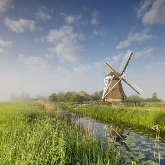 windmill-on-green-meadow-by-river-2022-02-02-03-48-07-utc-1.jpg